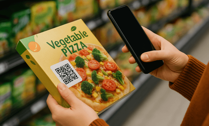 Person scanning a QR code on a frozen vegetable pizza box at the supermarket