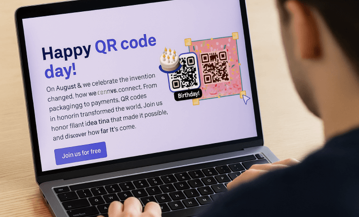 A person viewed from behind uses a laptop displaying QRCodeKIT’s QR Code Day landing page with a colorful birthday-themed QR code and celebratory message.