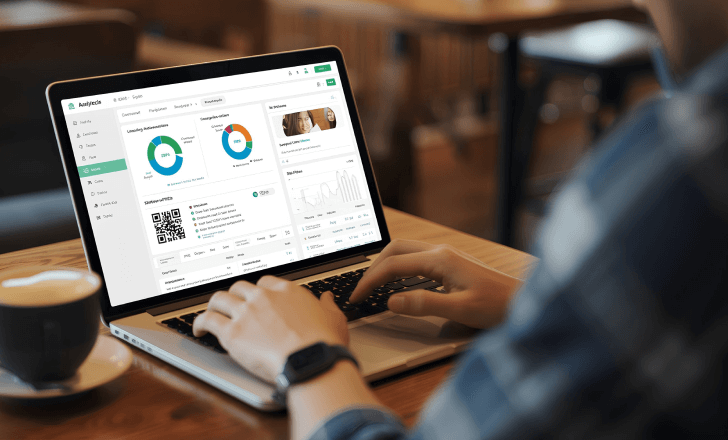 Freelancer analyzing free plan QR code analytics on a laptop.